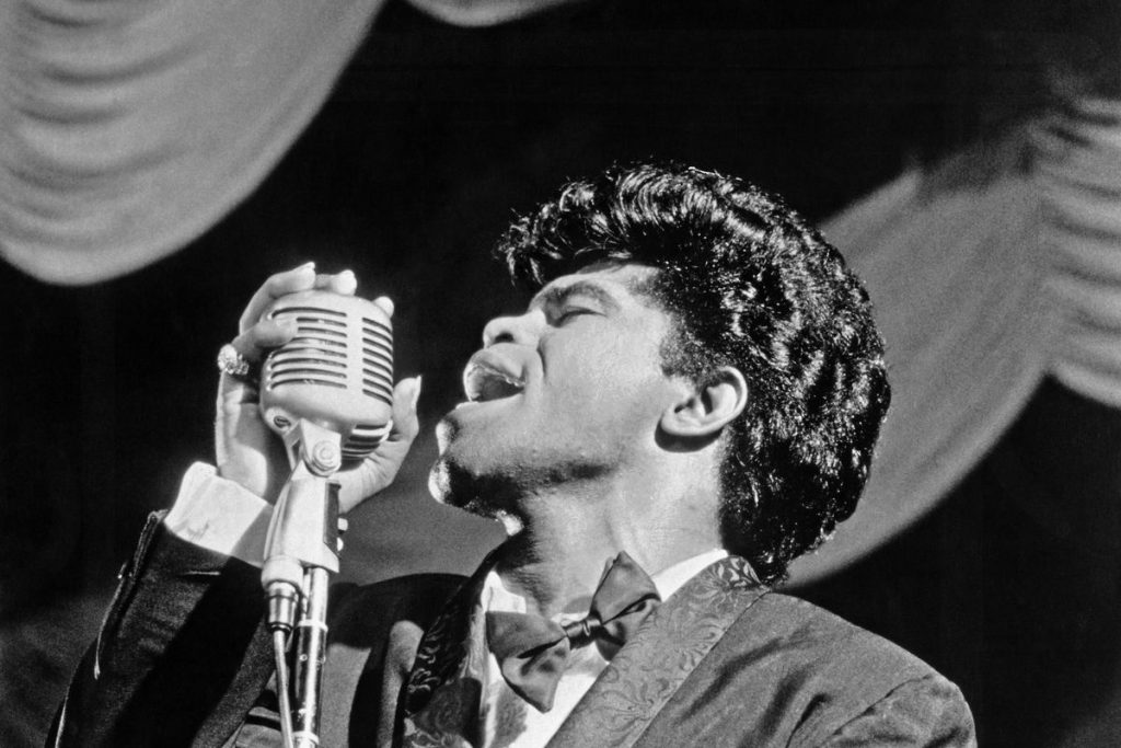 Le chanteur James Brown des années 60 en train de chanter dans un microphone vintage