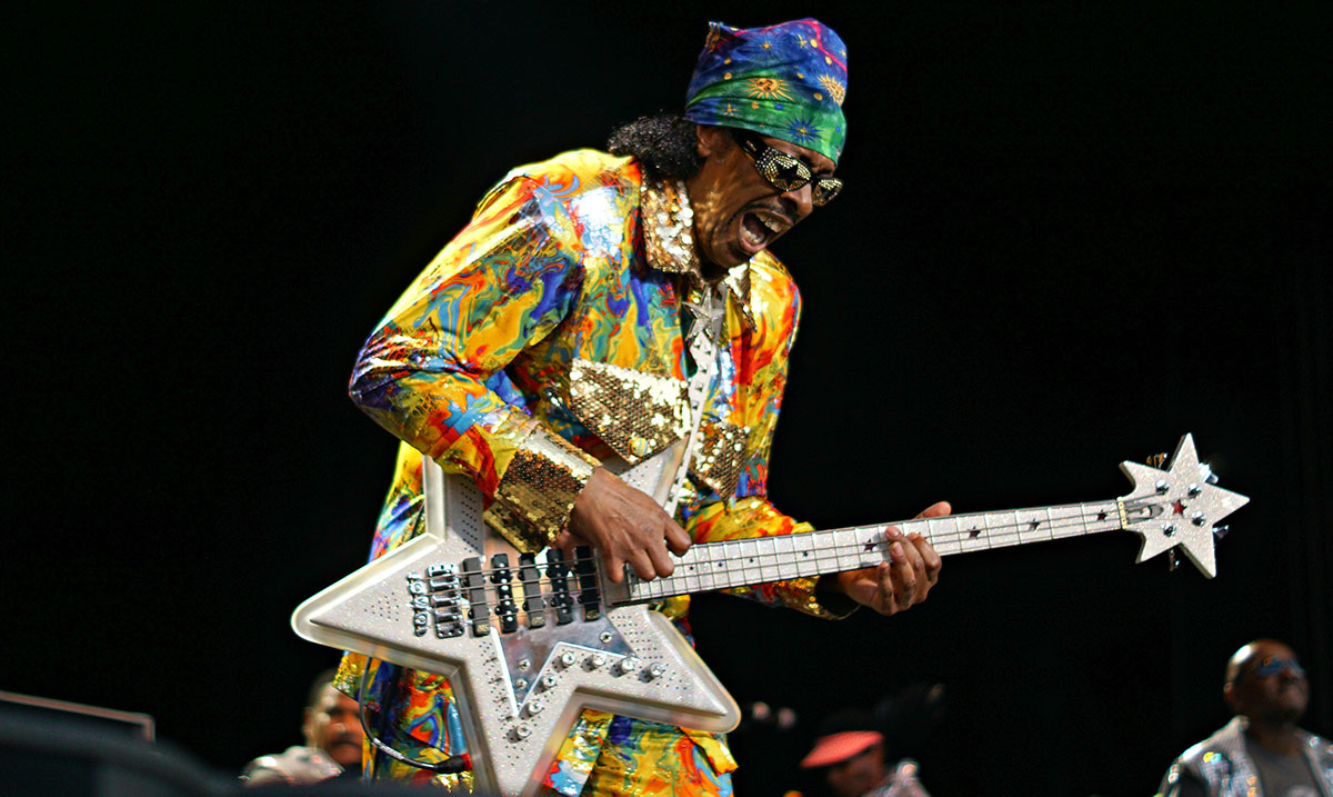 Le bassiste funk Bootsy Collins en train de jouer de la guitare électrique en forme d'étoile